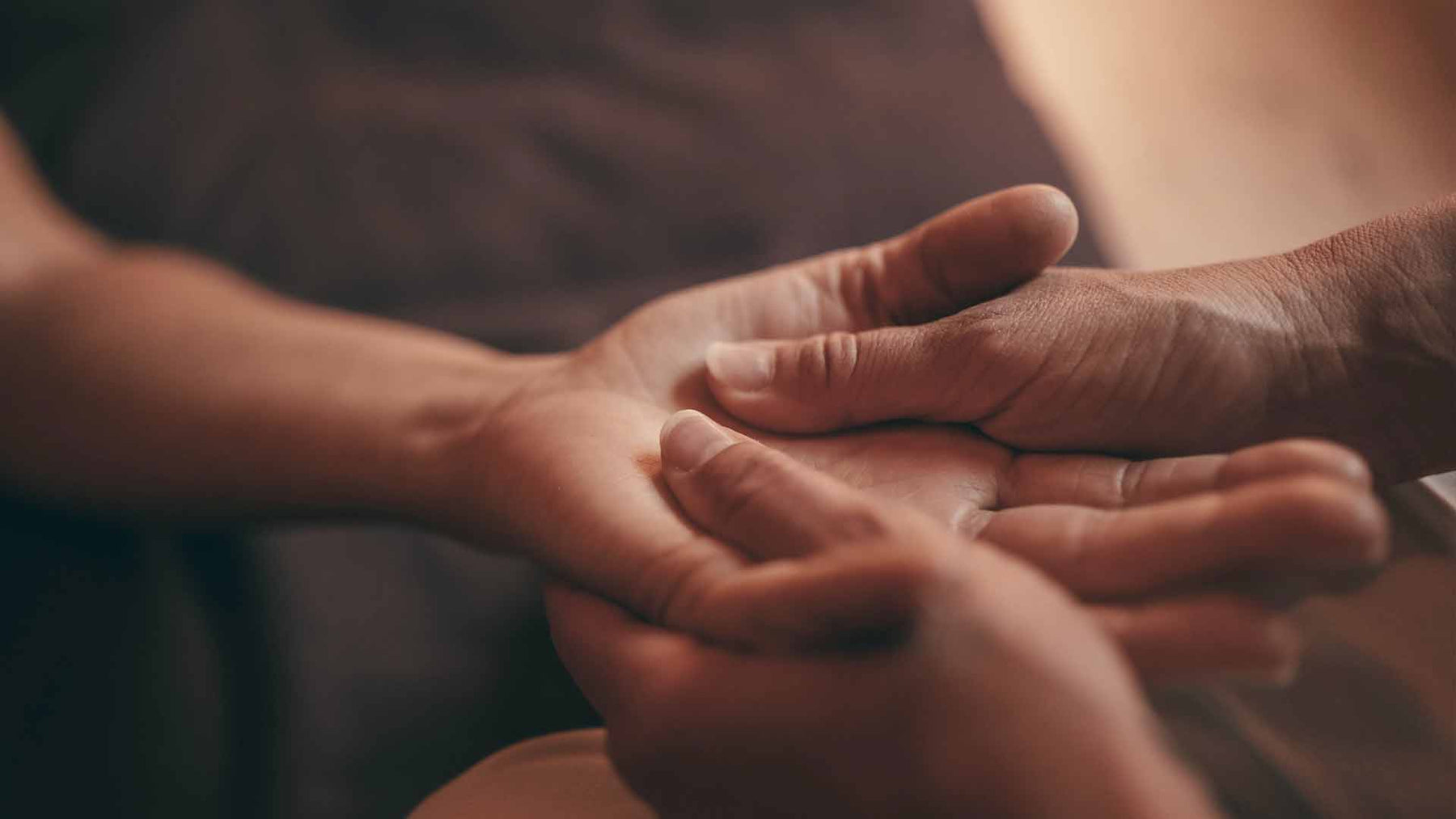 Physiotherapist performing hand massage on patient
